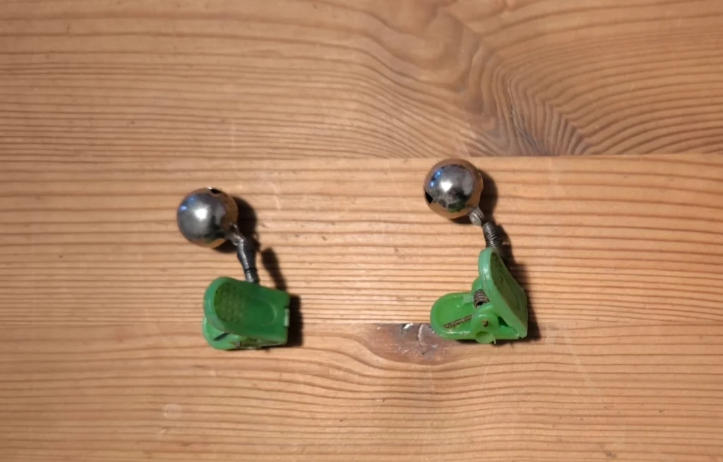 2 rod bells on a wooden table.