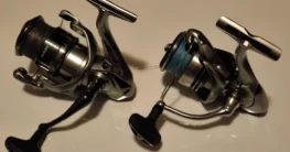 Shimano Nasci FC and Daiwa 23 Exceler LT spinning reels side-by-side on a white background for comparison.