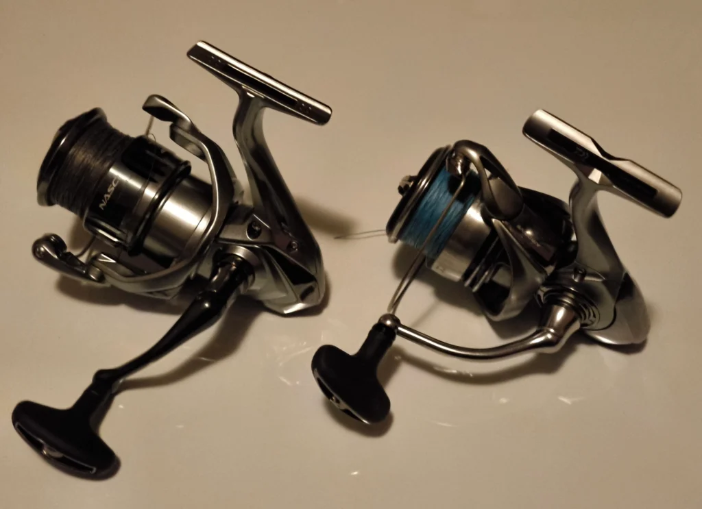 Shimano Nasci FC and Daiwa 23 Exceler LT spinning reels side-by-side on a white background for comparison.